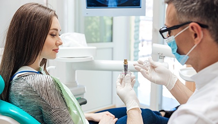 Dentist and patient examining dental implants