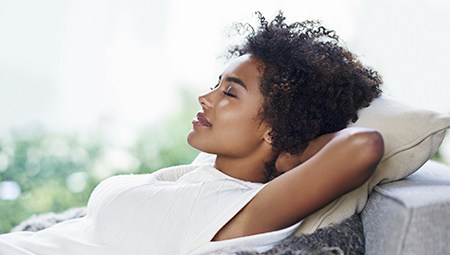 Relaxed woman with hands behind head